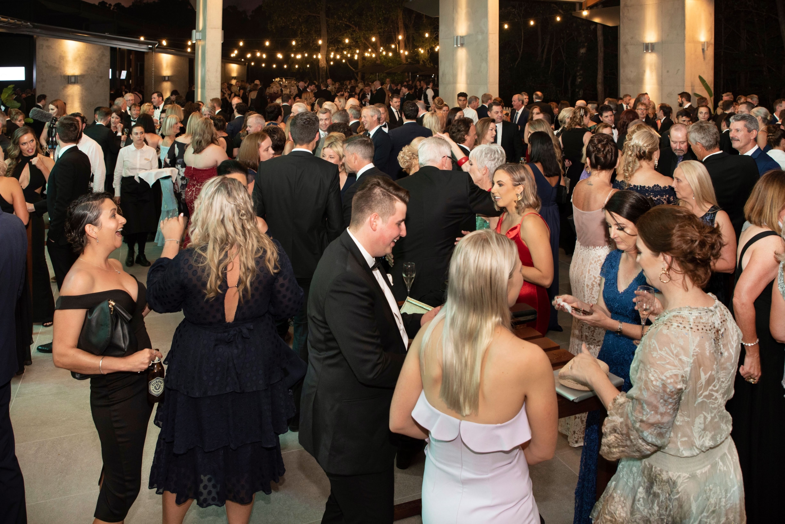 Large crowd mingles at charity event Crowd enjoying the charity fundraiser gala