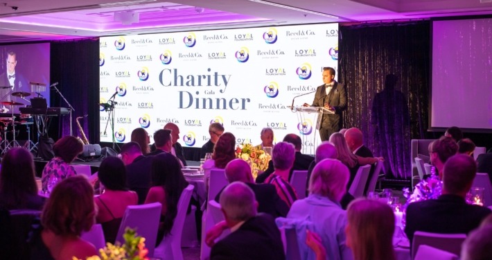 Charity dinner, emcee on stage in front of crowd
