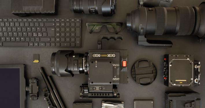 Flat lay of filming equipment with keyboard and eyeglasses on table