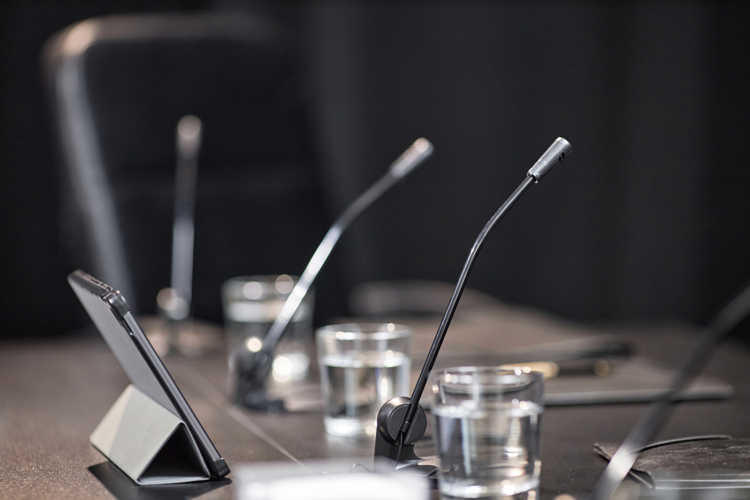 Microphone and Tablet Placed on Table in Meeting Room of Local Government